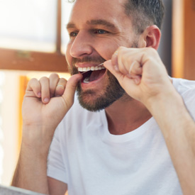 Man flossing his teeth